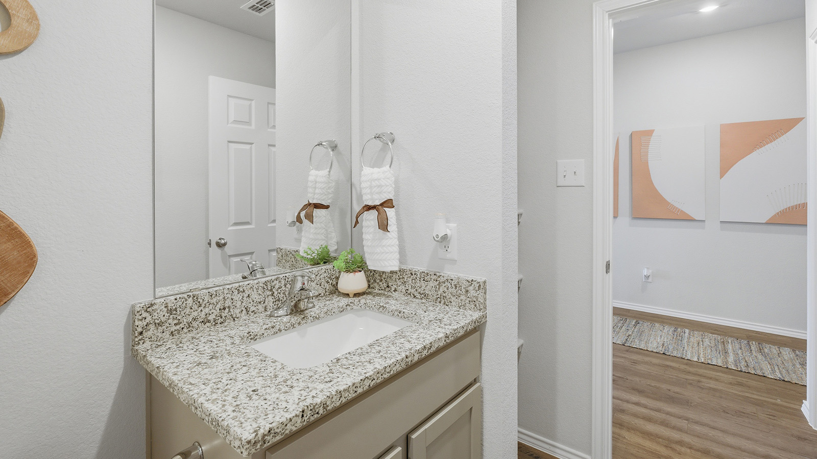 Eagles Landing Model Home secondary bathroom with single vanity sink and view of hallway.