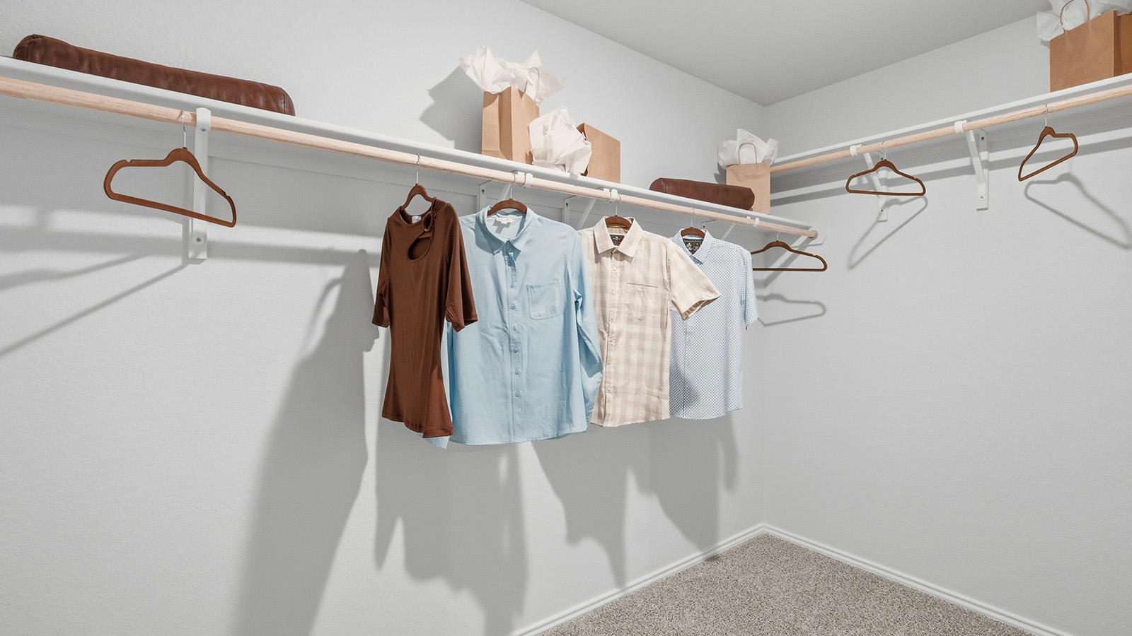 Eagles Landing Model Home primary bedroom walk-in closet with carpeted flooring and shelving for storage.