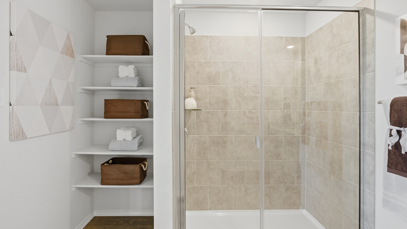 Eagles Landing Model Home primary bathroom with walk-in shower and shelving for storage.