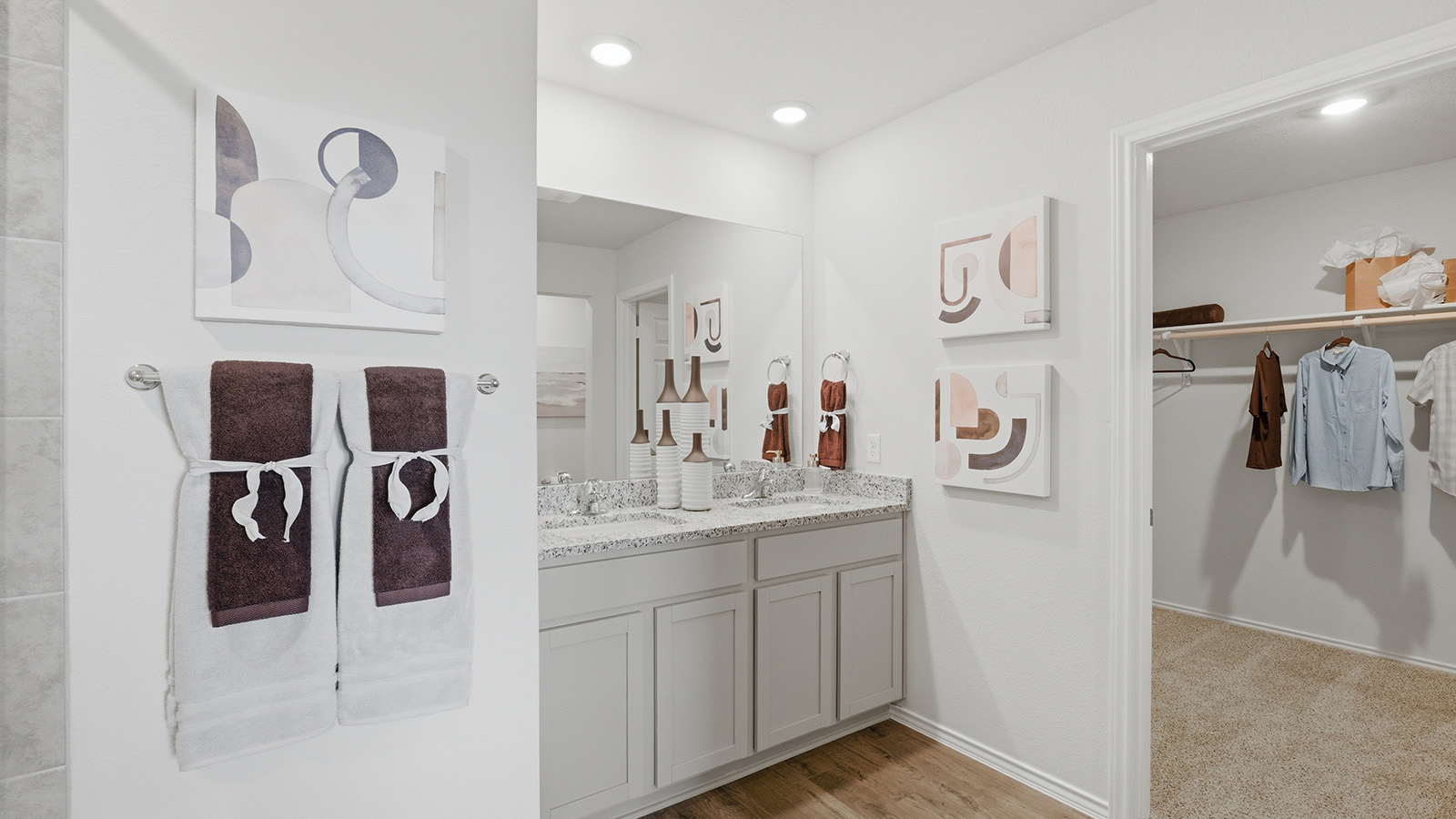 Eagles Landing Model Home primary bedroom with double vanity sink and view of primary walk-in closet.