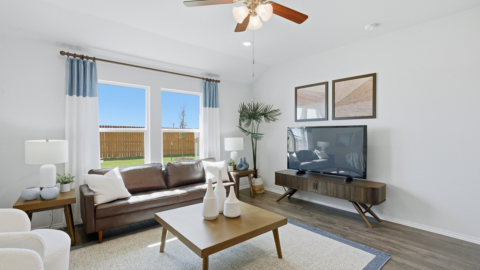 Eagles Landing Model Home living room with windows for lighting and sofa and tv.