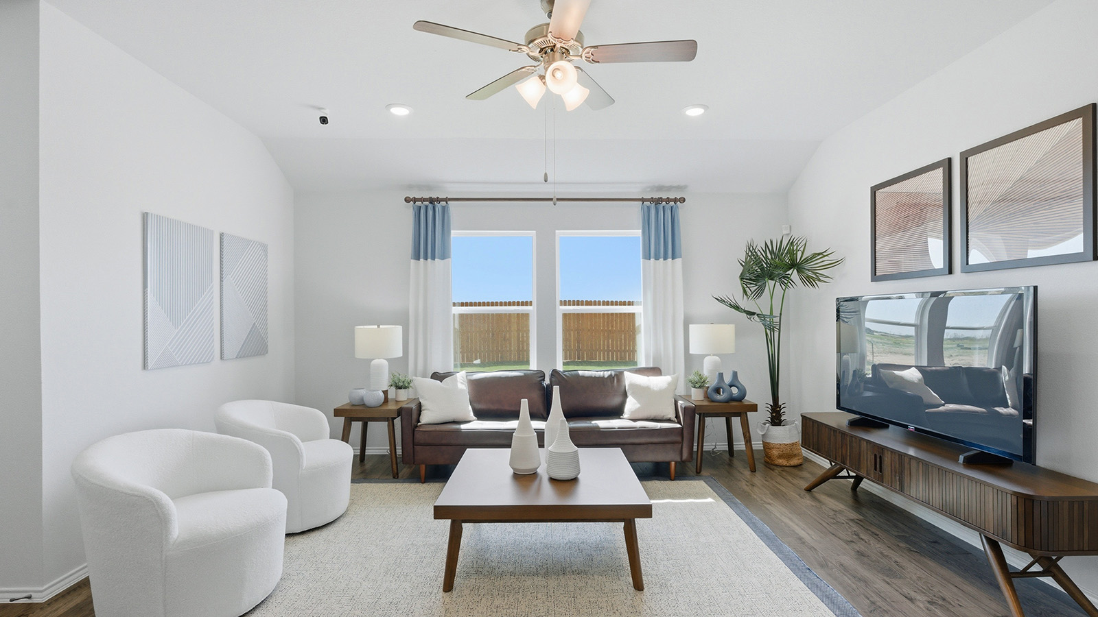 Eagles Landing Model Home living room with windows for lighting and sofa and tv.