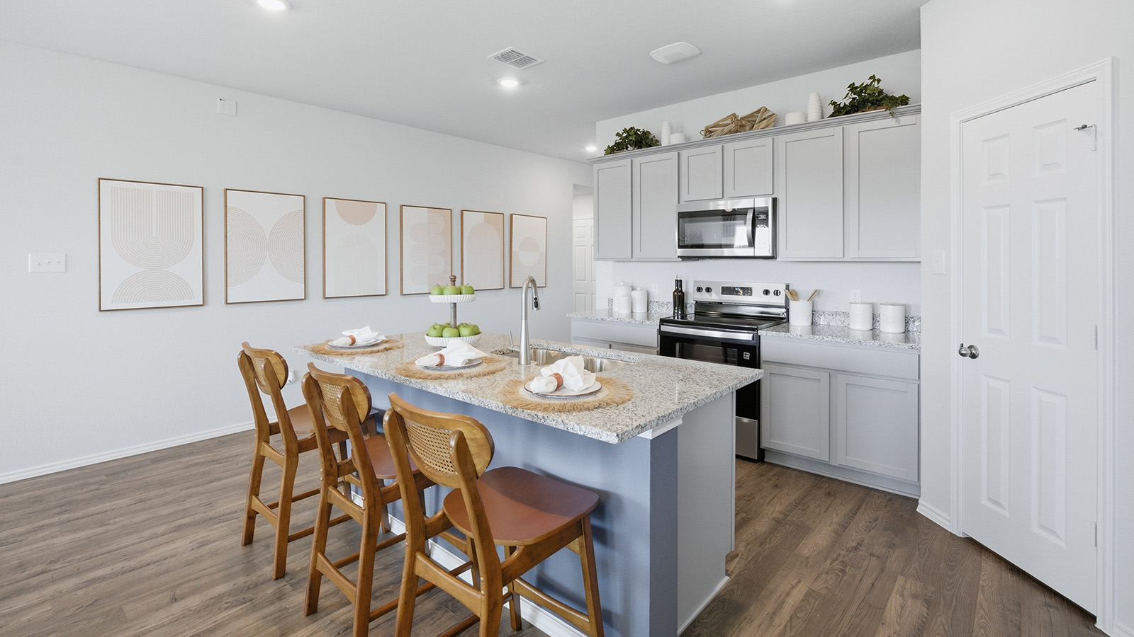Eagles Landing Model Home kitchen with kitchen island with light cabinets and granite countertops.