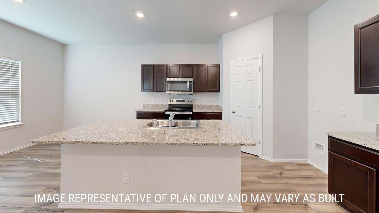 Emma kitchen with center kitchen island with granite countertops and view of dining room.