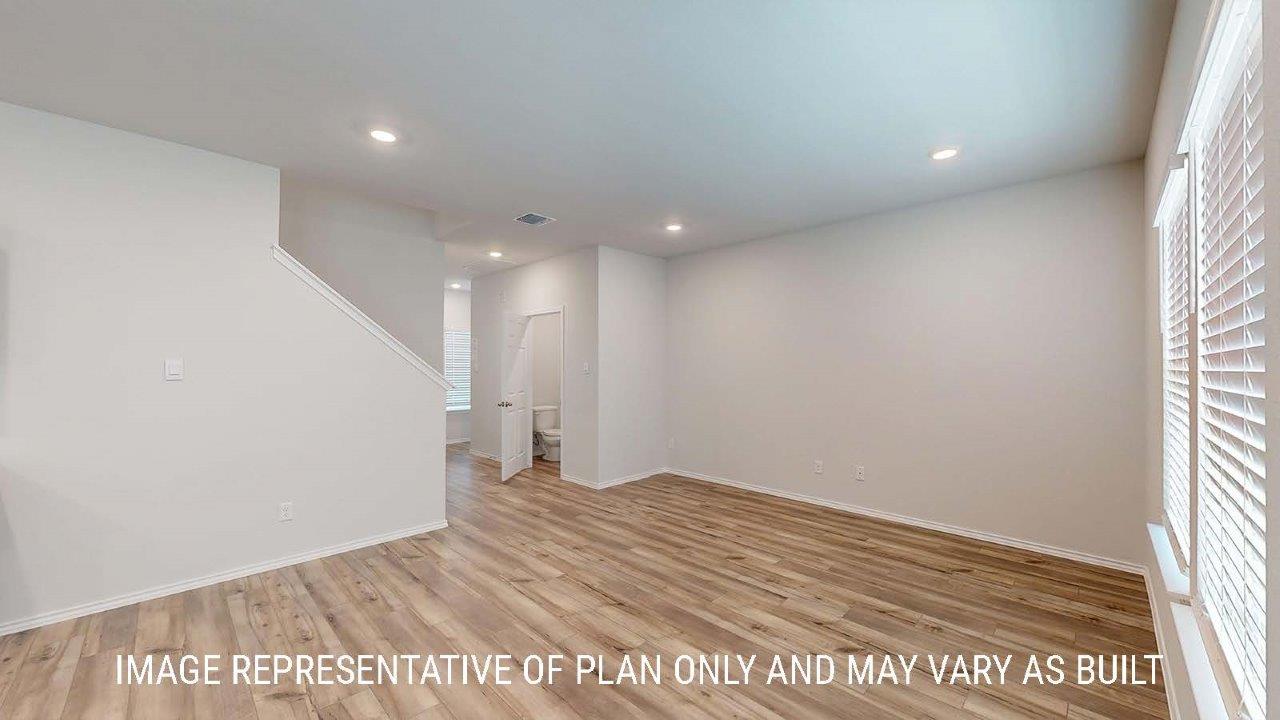 Emma living room with vinyl plank flooring and view of half bathroom and front hallway.