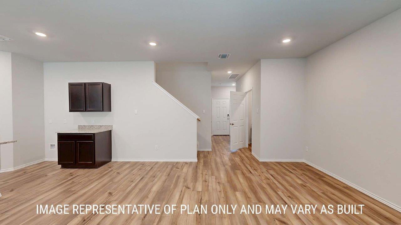 Emma living room with vinyl plank flooring and view of kitchen and entryway.