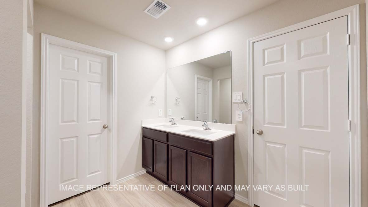 Bellvue primary bath with dark cabinets and white countertops and vinyl plank flooring.
