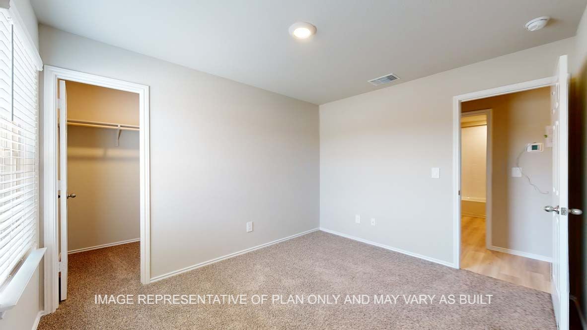 Bellvue secondary bedroom with view into walk-in closet.