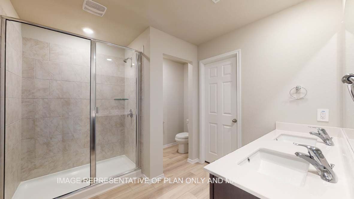 Bellvue primary bathroom with walk-in shower including clear glass enclosure and ceramic tile surround.