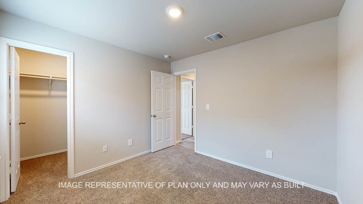 Fargo secondary bedroom with carpet flooring and window.