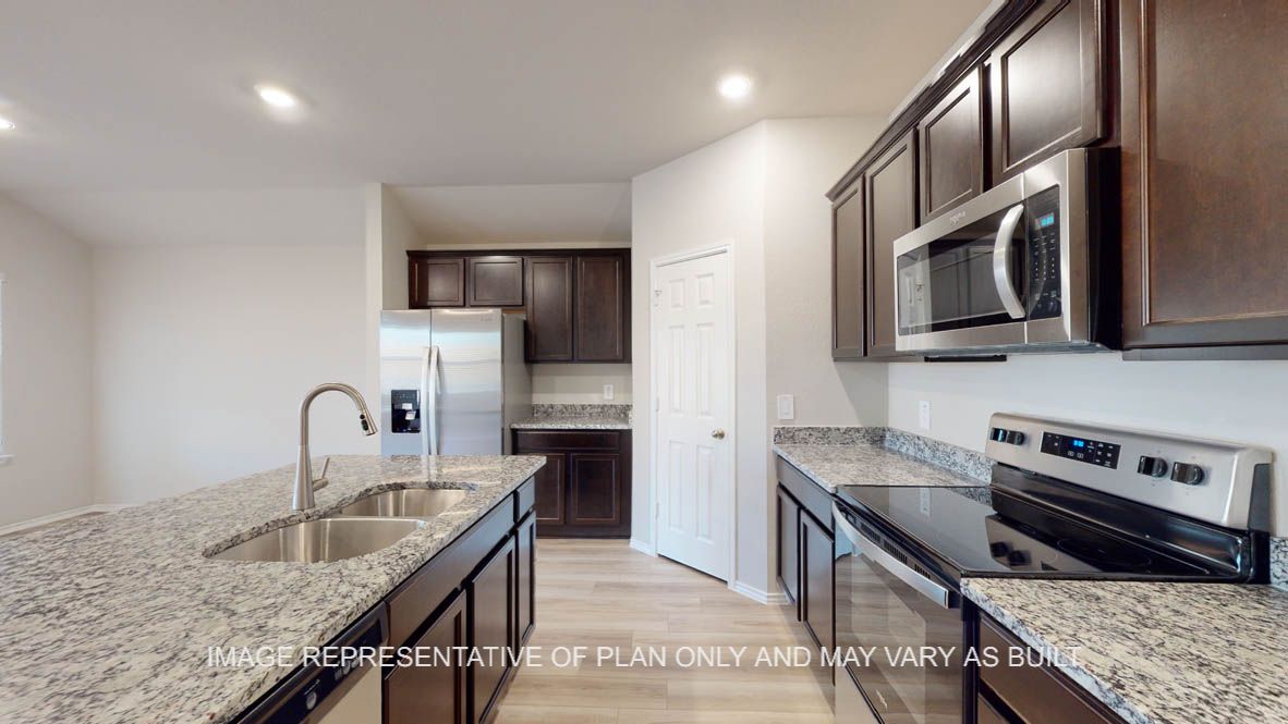 Texas Cali kitchen with dark cabinet, granite countertops and vinyl plank flooring.
