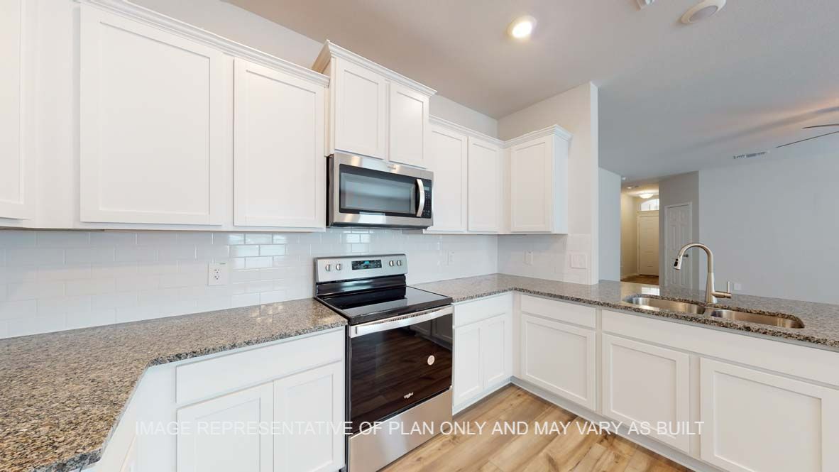 Roosevelt kitchen with white cabinets and granite countertops.