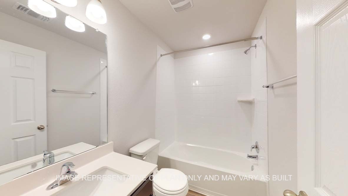 Roosevelt secondary bath with tub and shower combination and white countertops.