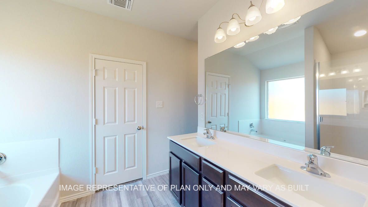 Prescott primary bathroom with dark cabinets and white countertops.