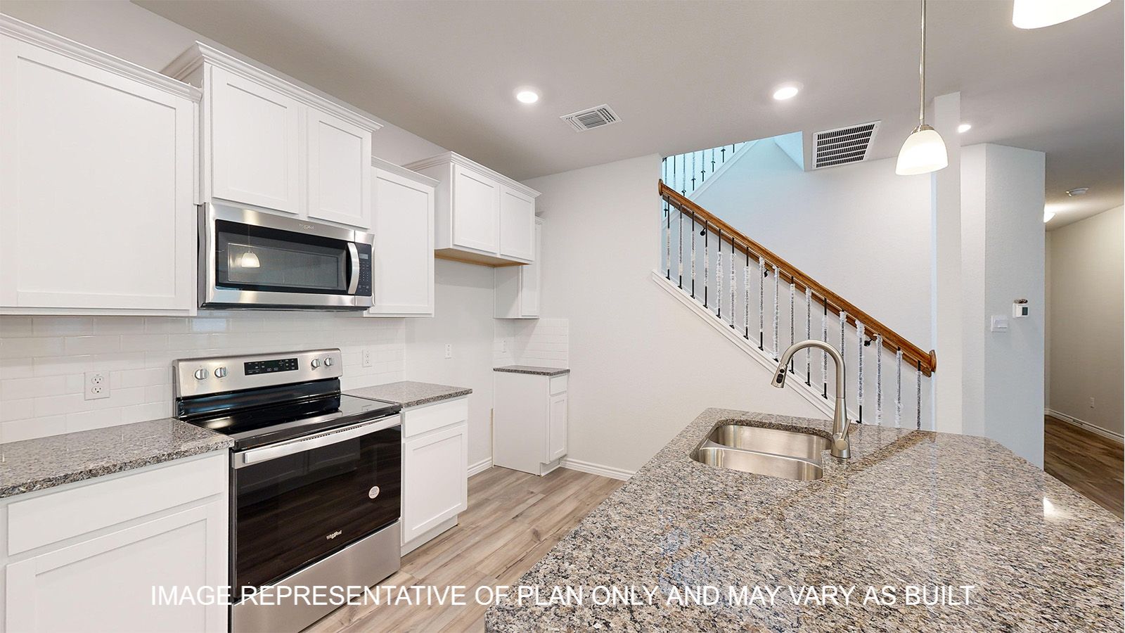 Magnolia kitchen with white cabinets and vinyl plank flooring.