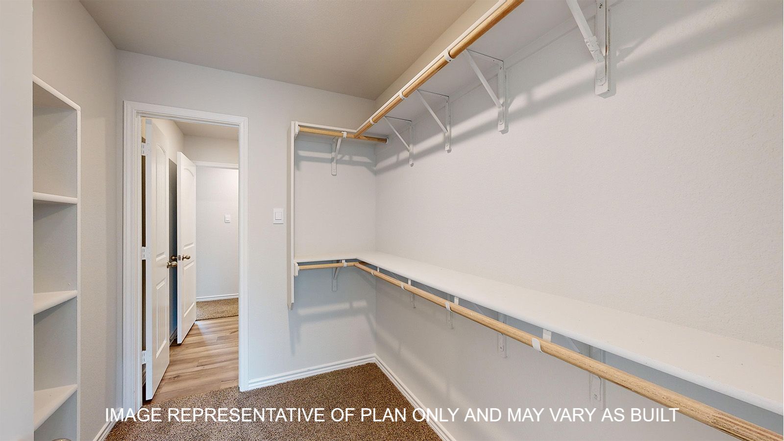 Magnolia primary bedroom with carpet flooring and access into primary bathroom.