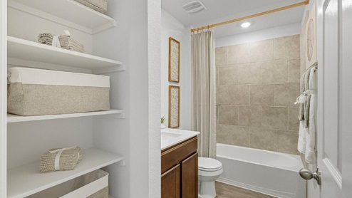 Mesa Ridge model home secondary bathroom with single vanity sink and bath tub and shower combo.