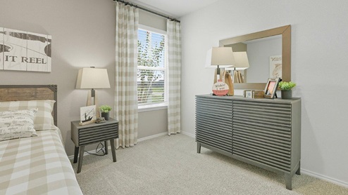 Mesa Ridge model home secondary bedroom with carpeted flooring and window for lighting.