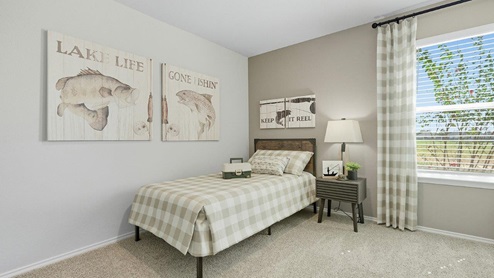 Mesa Ridge model home secondary bedroom with carpeted flooring and window for lighting.