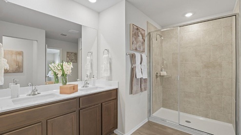 Mesa Ridge model home primary bathroom with double vanity sink and walk-in shower.