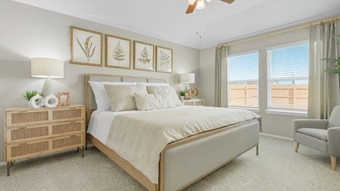 Mesa Ridge model home primary bedroom with carpeted flooring and windows for lighting.