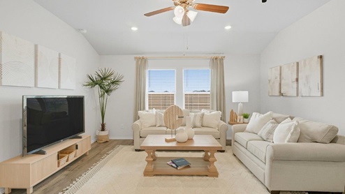 Mesa Ridge model home living room with windows for lighting and view of back yard.