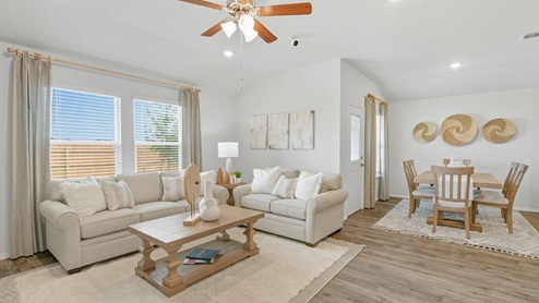 Mesa Ridge model home living room with view of open concept dining room and back door.