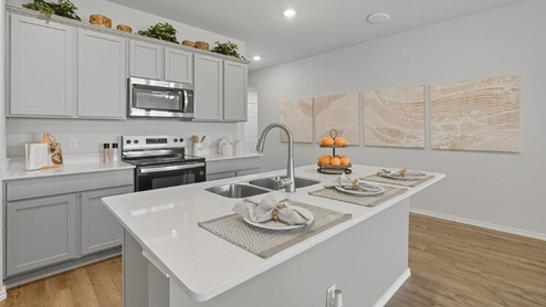 Mesa Ridge model home kitchen with center kitchen island with granite countertops.
