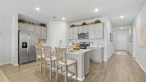 Mesa Ridge model home kitchen with center kitchen island and view of entry way.
