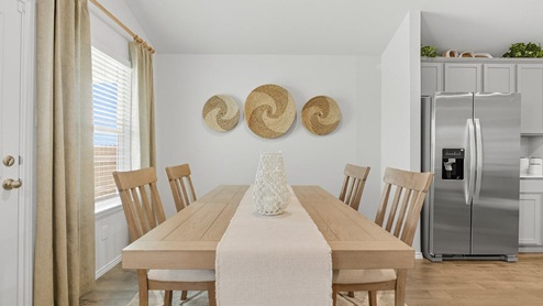 Mesa Ridge model home dining room with view of kitchen and back yard.