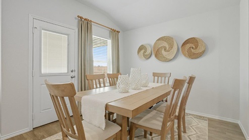 Mesa Ridge model home dining room with view of back door and window for lighting.