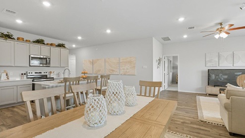 Mesa Ridge model home dining room with view of open concept kitchen and living room.