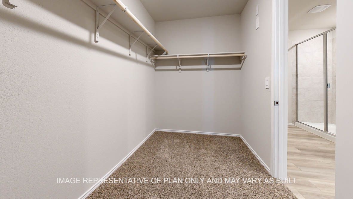 Seabrook primary bedroom walk-in closet with carpet flooring.