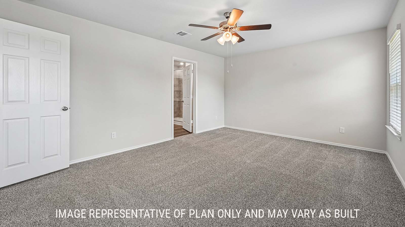 Madison primary bedroom with carpeted flooring and view of primary bathroom.