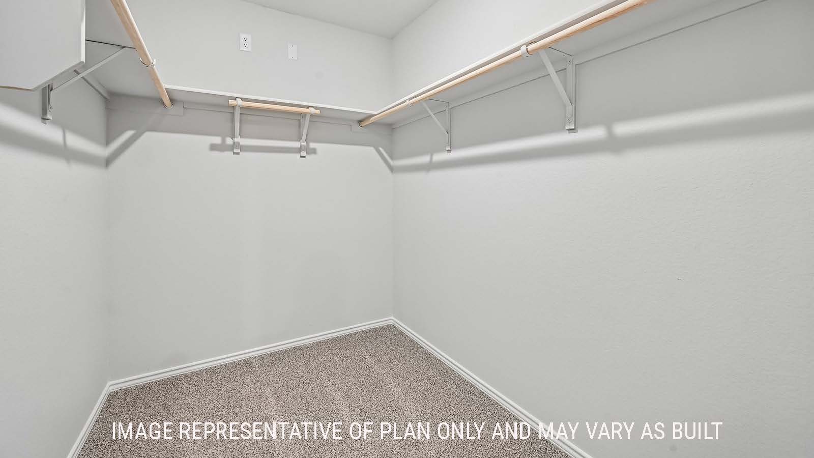 Madison primary bedroom closet with carpeted flooring and shelving for storage.