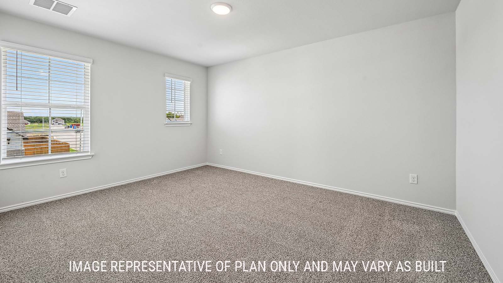 Madison secondary bedroom with carpeted flooring and windows for natural lighting.