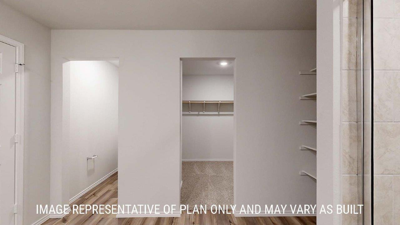Emma primary bathroom with shelving for storage and view of primary walk-in closet.