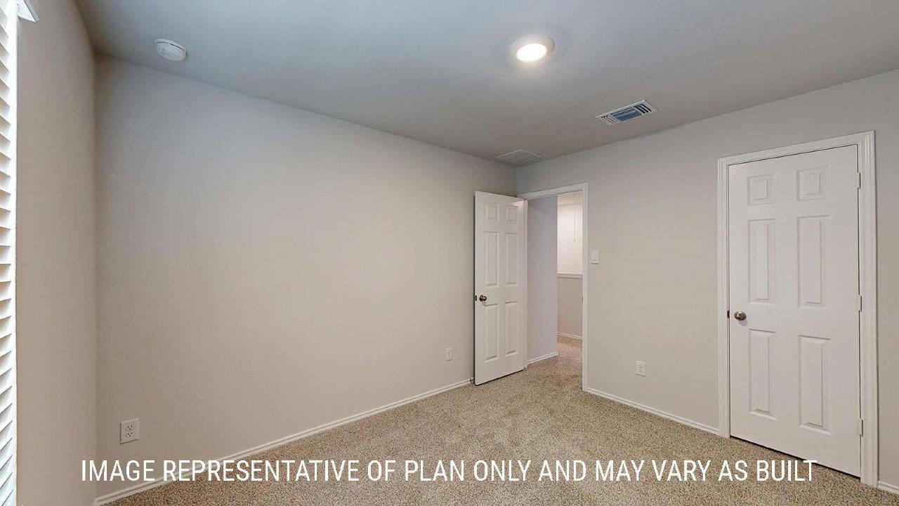 Emma secondary bedroom with carpeted flooring and closet.