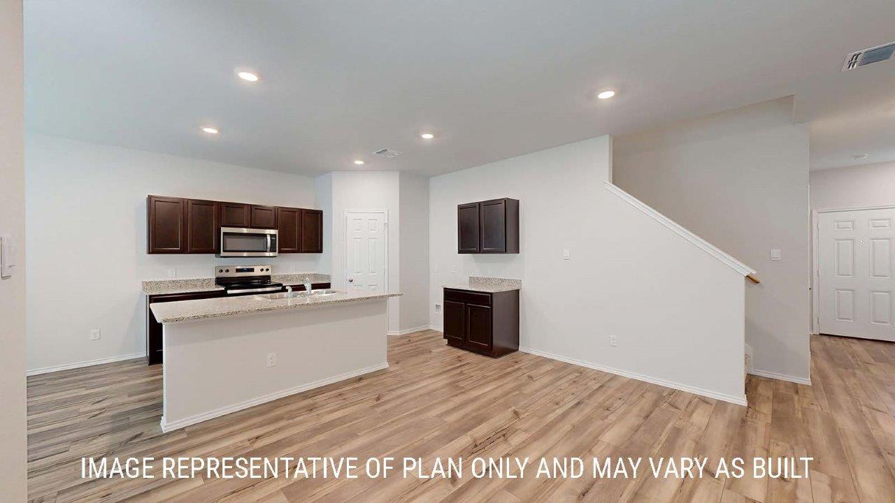 Emma living room with vinyl plank flooring and view of kitchen and entryway.
