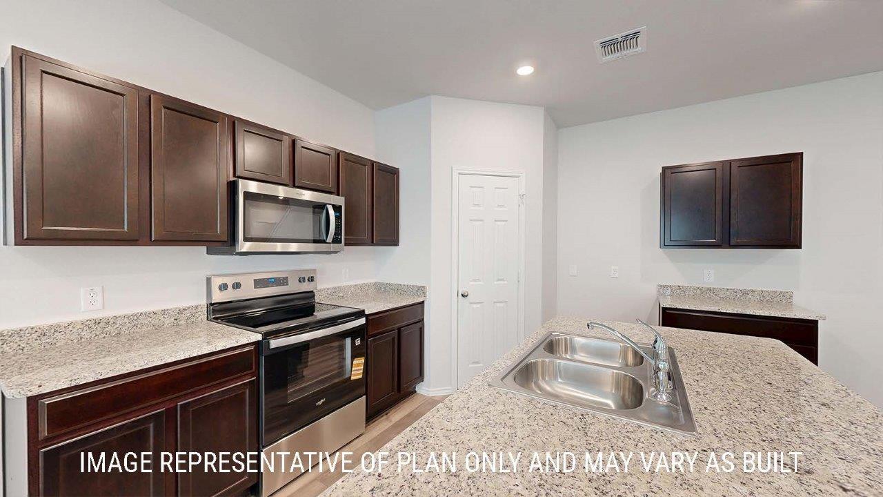 Emma kitchen with dark cabinets and granite countertops.
