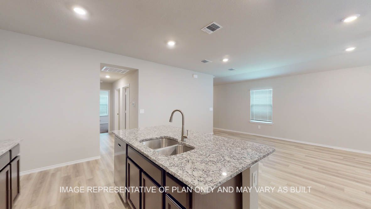 Camden kitchen island with granite countertop and view into living areas.