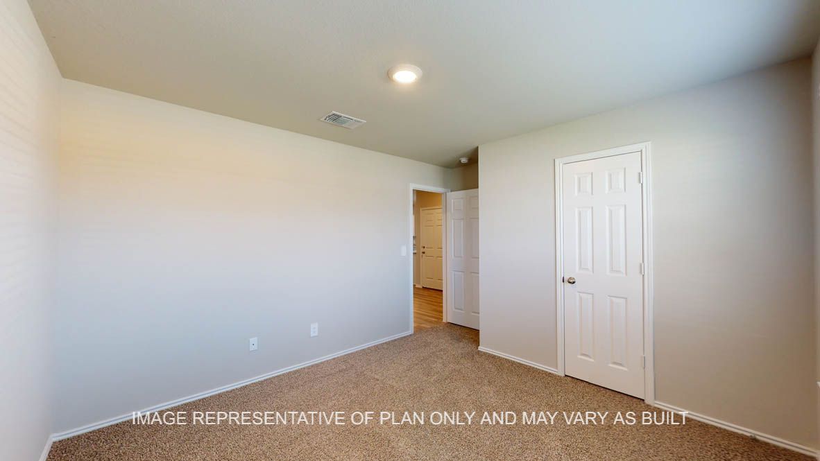 Kingston secondary bedroom with carpet flooring and closet door.