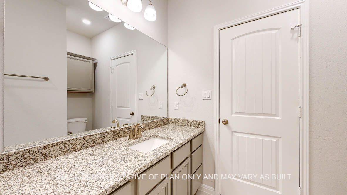Parker secondary bath with granite countertops and wood look tile flooring.