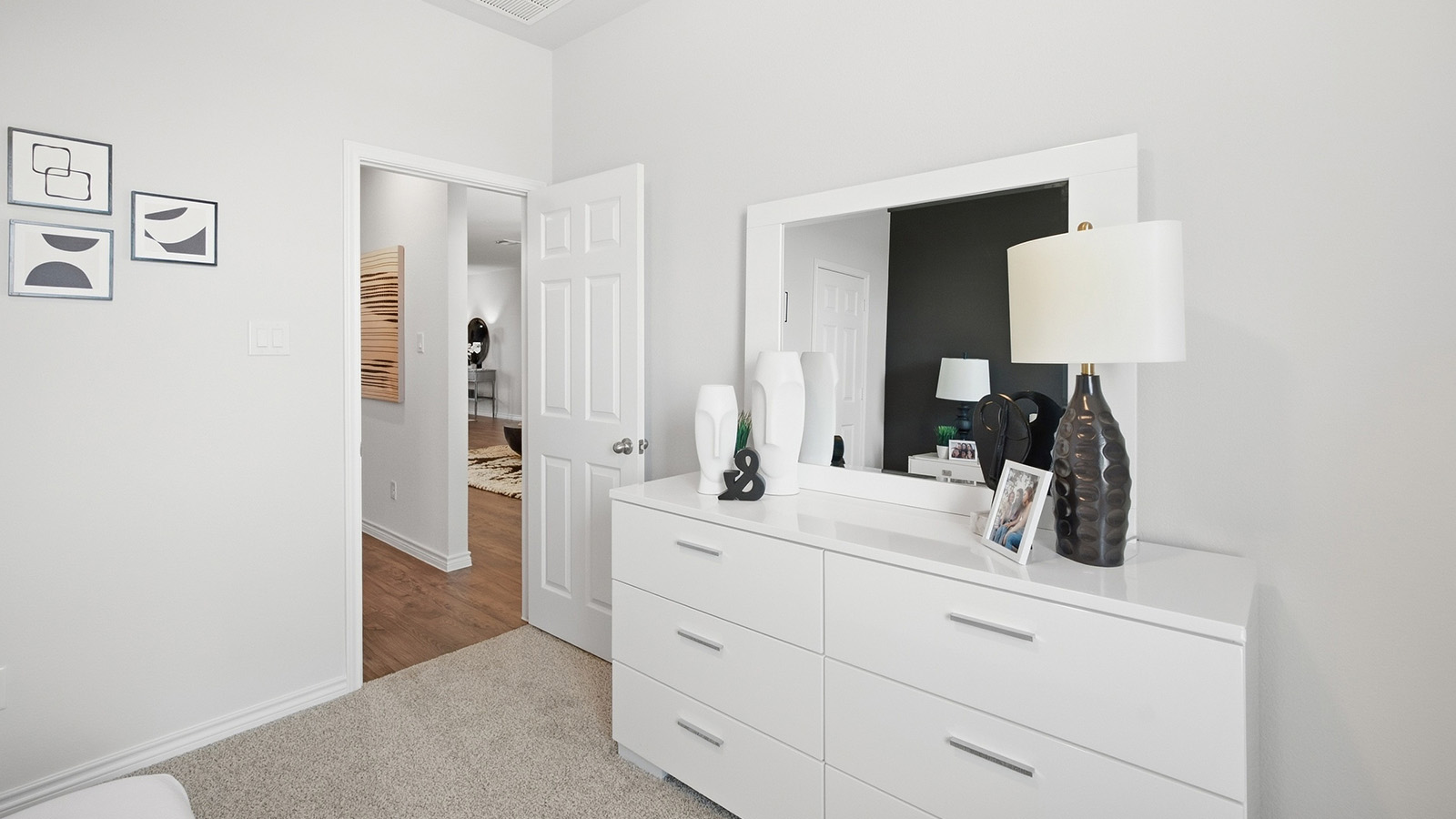 Homestead Model secondary bedroom with carpeted flooring and view of front hallway.