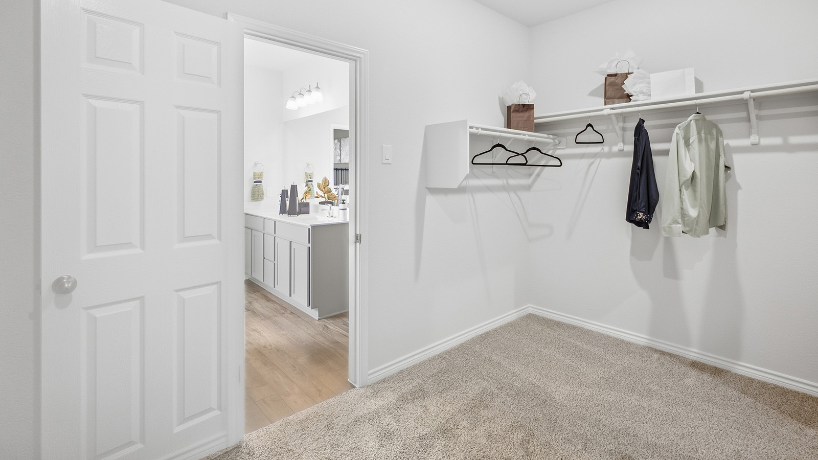 Homestead Model primary bedroom closet with carpeted flooring and shelving for storage.