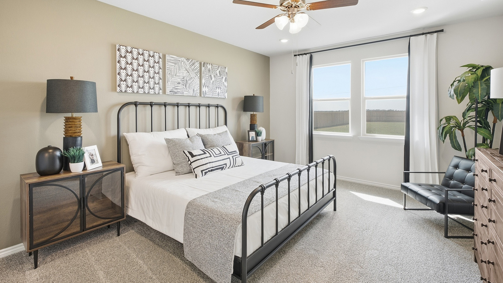 Homestead Model primary bedroom with carpeted flooring and windows for natural lighting.