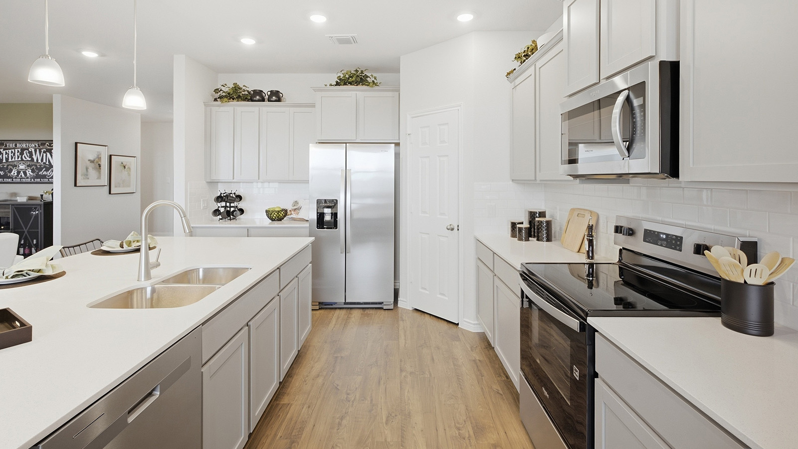 Homestead Model  kitchen with kitchen island with light cabinets and granite countertops.
