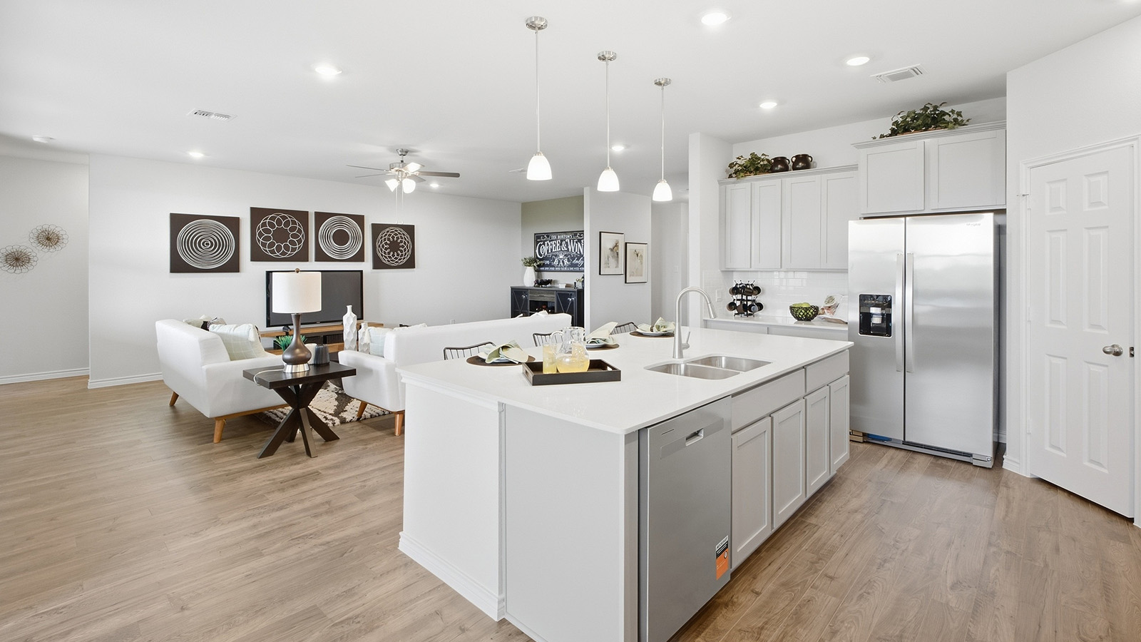 Homestead Model kitchen with kitchen island and view of open concept living room and dining room.