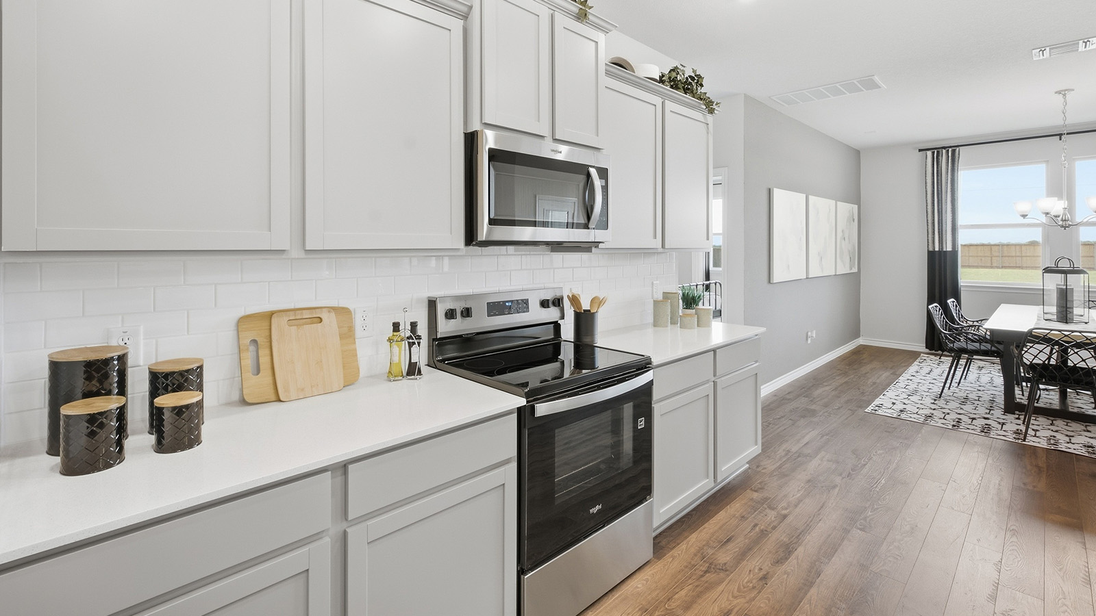 Homestead Model  kitchen with kitchen island with light cabinets and granite countertops.