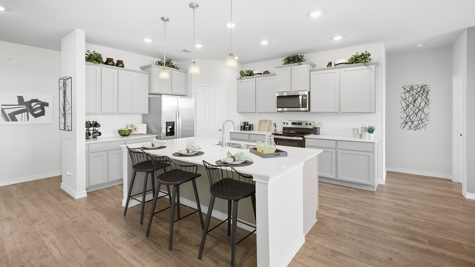 Homestead Model kitchen with kitchen island with light cabinets and granite countertops.